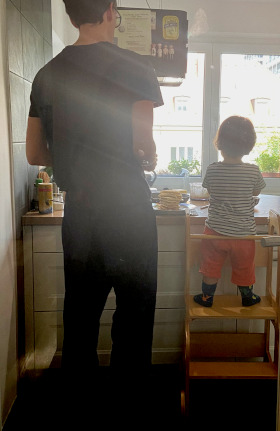 Vater und Kind zusammen kochen mit Montessori Lernturm.